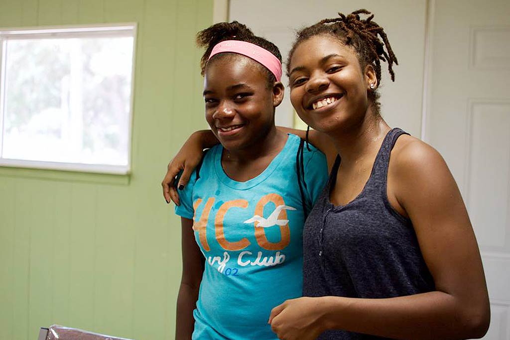 Two girls arm in arm smiling at the camera